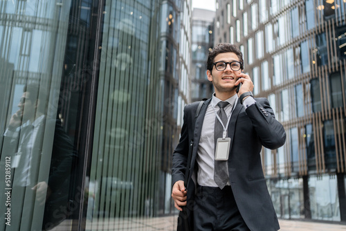 A financier with glasses a man uses a phone in his hands calls a colleague
