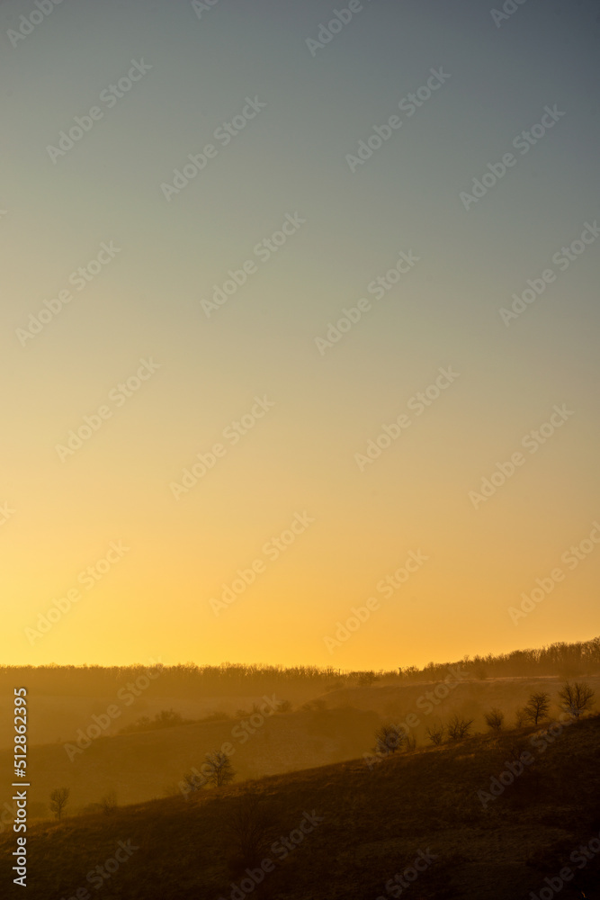 Obraz premium Sunrise over the hills , trees on the hiil , mountains and hill, golden lights of the sun .