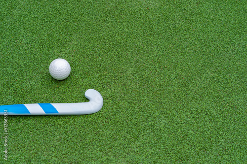 Field hockey stick and ball on green grass. Horizontal sport theme poster, greeting cards, headers, website and app.