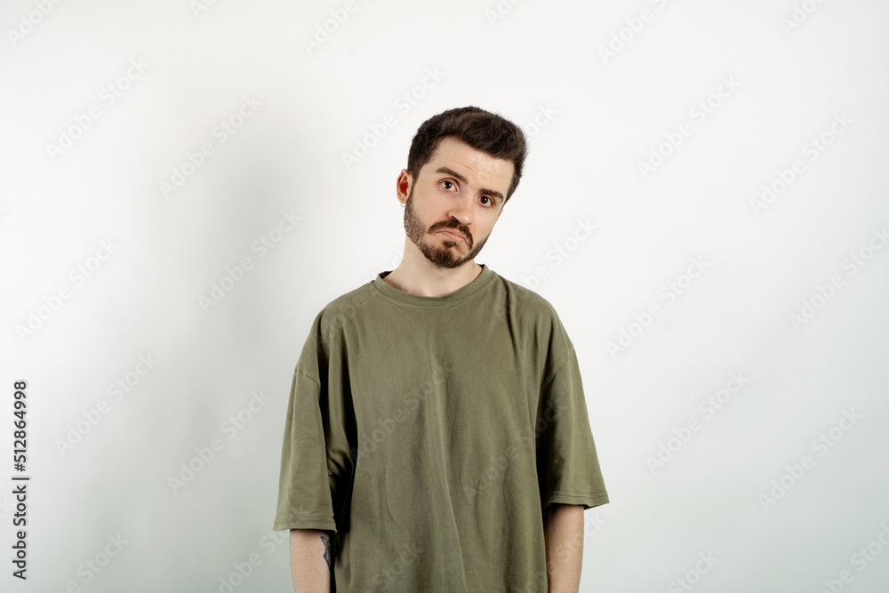 Fototapeta premium Handsome caucasian man wearing khaki t-shirt posing isolated over white background crying wipes tears losing his job. I don't know.