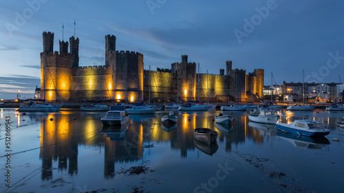 Caernarfon castle during the blue hour high tide lights reflected in sea long exposure photo