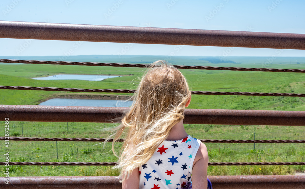 Children looking through a fence at the Feed Yard Scenic Overlook outside of Dodge City, Kansas. Children looking through a fence at the Feed Yard Scenic Overlook outside of Dodge City, Kansas.