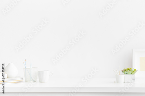 Office desk, white table with supplies, coffee mug and empty copy space. White, simple interior workspace..	