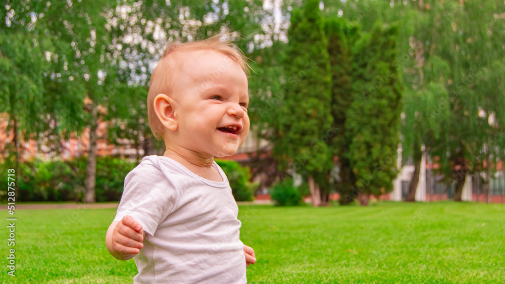 Funny baby girl sitting on the grass laughs and smiles. Funny baby girl sitting on the grass laughs and smiles.