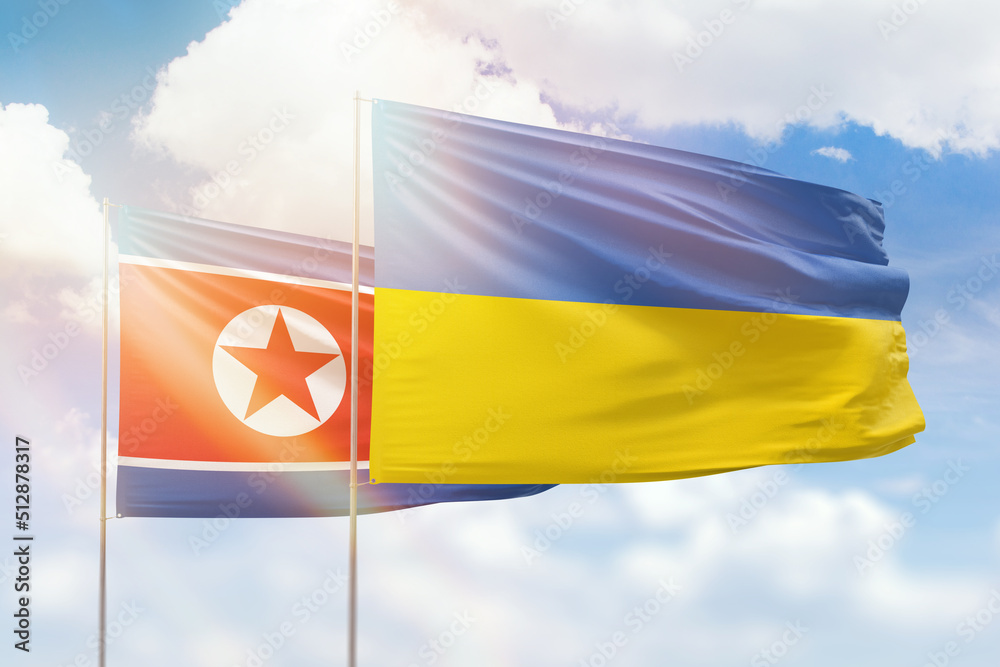 Sunny blue sky and flags of ukraine and north korea Sunny blue sky and flags of ukraine and north korea