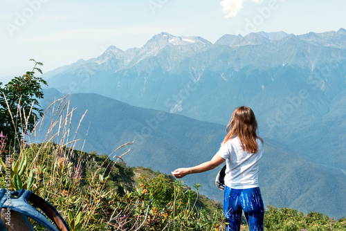 Happy woman rejoicing at view of mountain range in summer hike