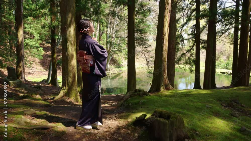 春の古いお寺を散策する和服の女性