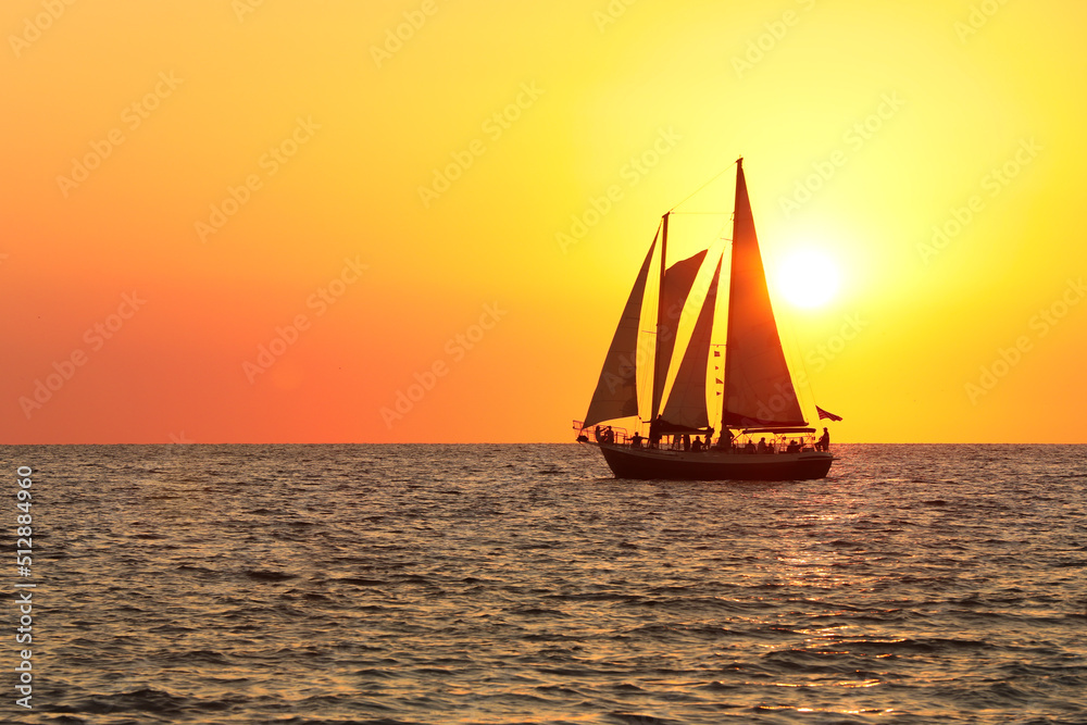 sail boat silhouette in the sun set at the beach