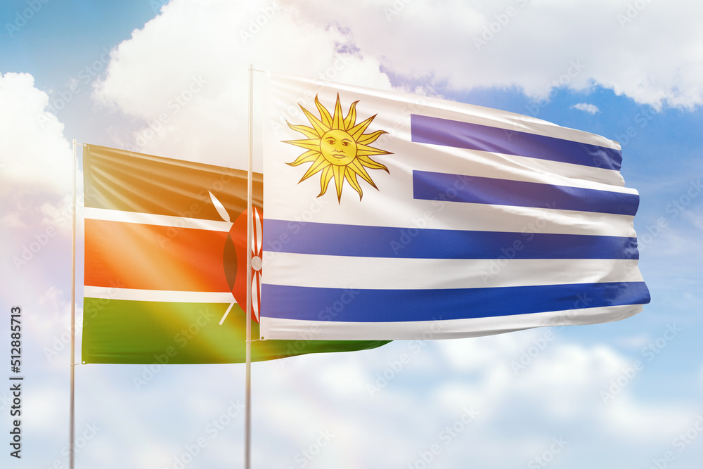 Obraz premium Sunny blue sky and flags of uruguay and kenya