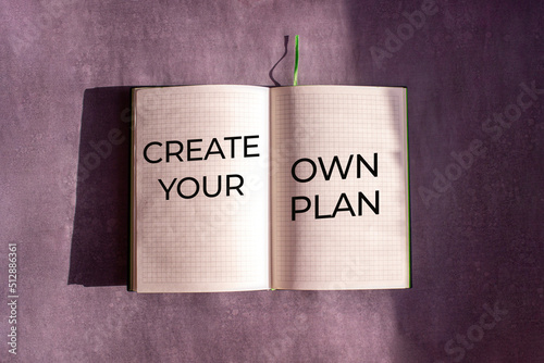 An open notebook is on the gray background. The word 
