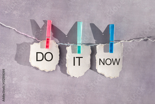 Tableau sur toile Paper sheets on a rope secured with clothespins with words Do It Now