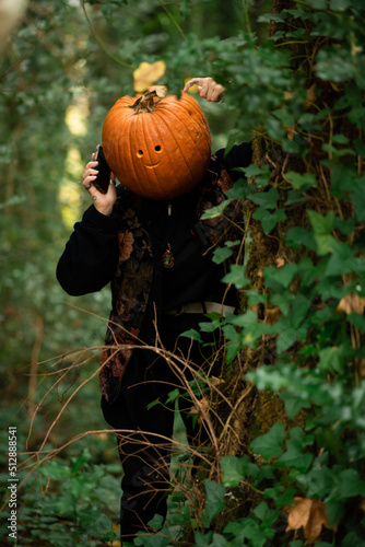 Jack o lantern on the phone in the forest