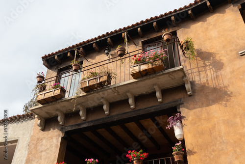 top of a medieval style building house with flowers on the balcony in a medieval italian tuscany villa in Val'Quirico, Tlaxcala, Puebla, Mexico photo