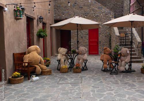 Big Teddy bears at the table in a street restaraurant in a new medieval italian tuscany style town villa in Val'Quirico, Tlaxcala, Puebla, Mexico photo