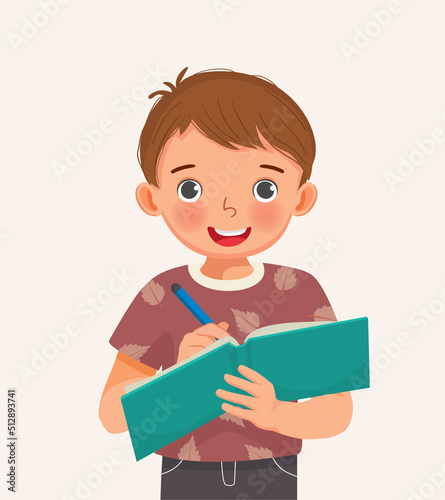 Cute little boy student holding pen and notebook writing making note