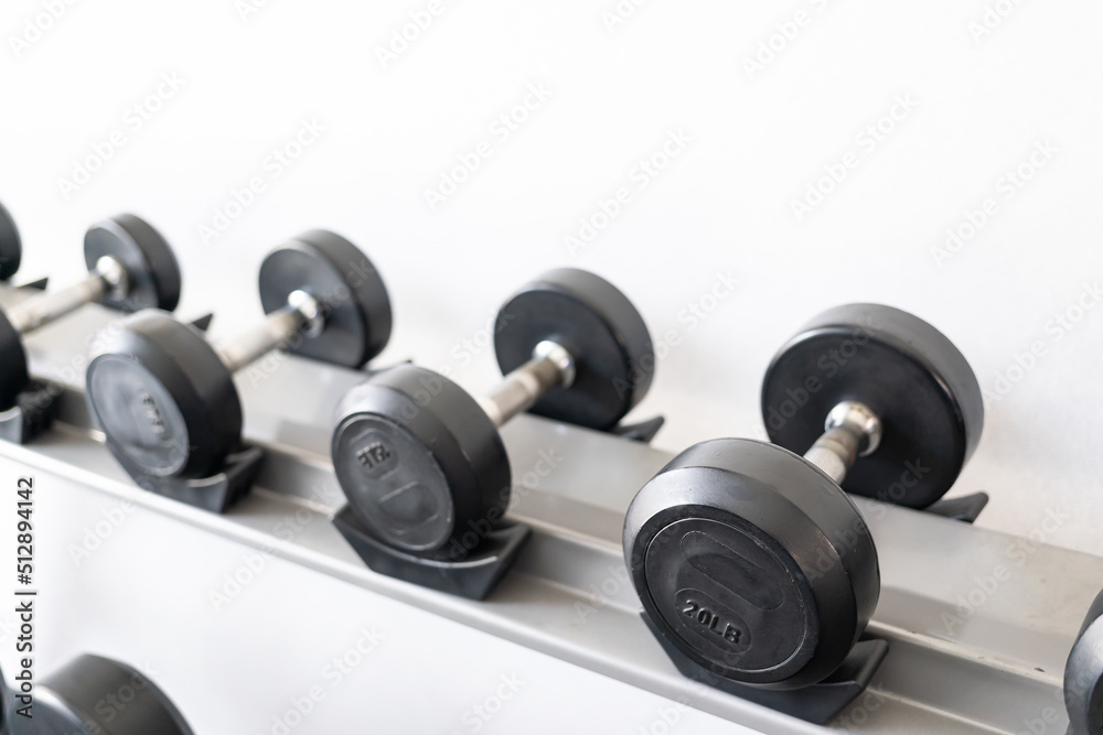 Stand with dumbbells. Sports and fitness room. Weight Training Equipment. Black dumbbell set, many dumbbells on rack in sport fitness center Stand with dumbbells. Sports and fitness room. Weight Training Equipment. Black dumbbell set, many dumbbells on rack in sport fitness center