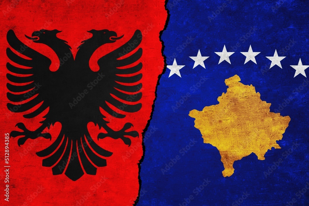 Albania and Kosovo painted flags on a wall with a crack. Albania and Kosovo relations. Kosovo