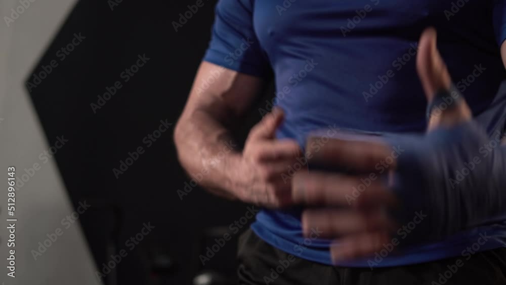 Strong boxer man wrap hands protection knuckle, Man is wrapping hands with boxing wraps for training and active exercise Strong boxer man wrap hands protection knuckle, Man is wrapping hands with boxing wraps for training and active exercise