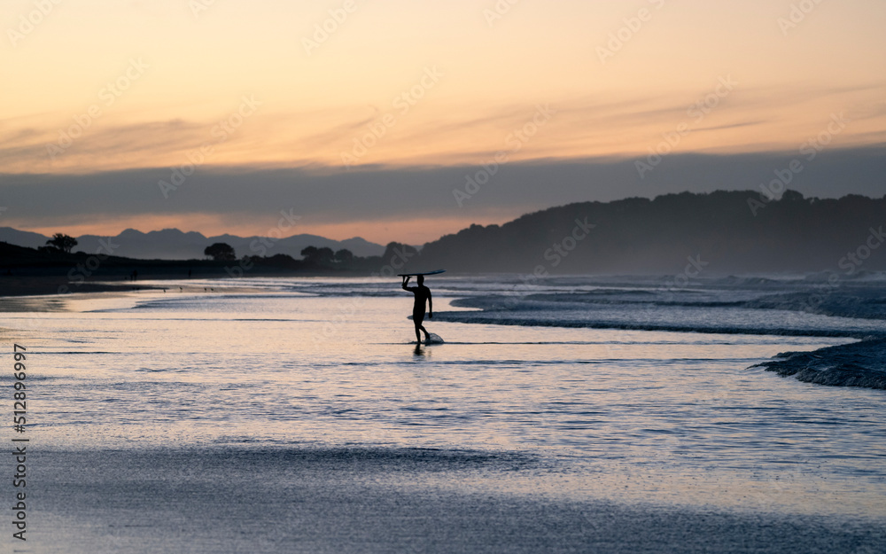 Sunset surfer on the beach