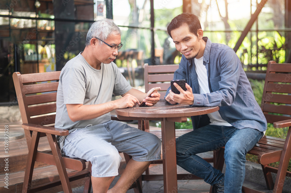 Asian family father and son looking on smartphone Asian family father and son looking on smartphone