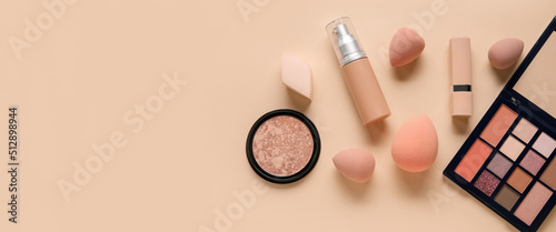 Quadro su tela Makeup sponges and different cosmetics on beige background with space for text,