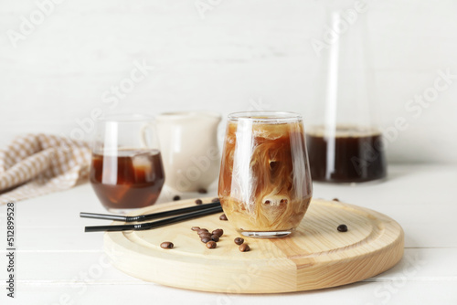 Leinwand Poster Glass of cold brew coffee with milk and straws on white wooden table