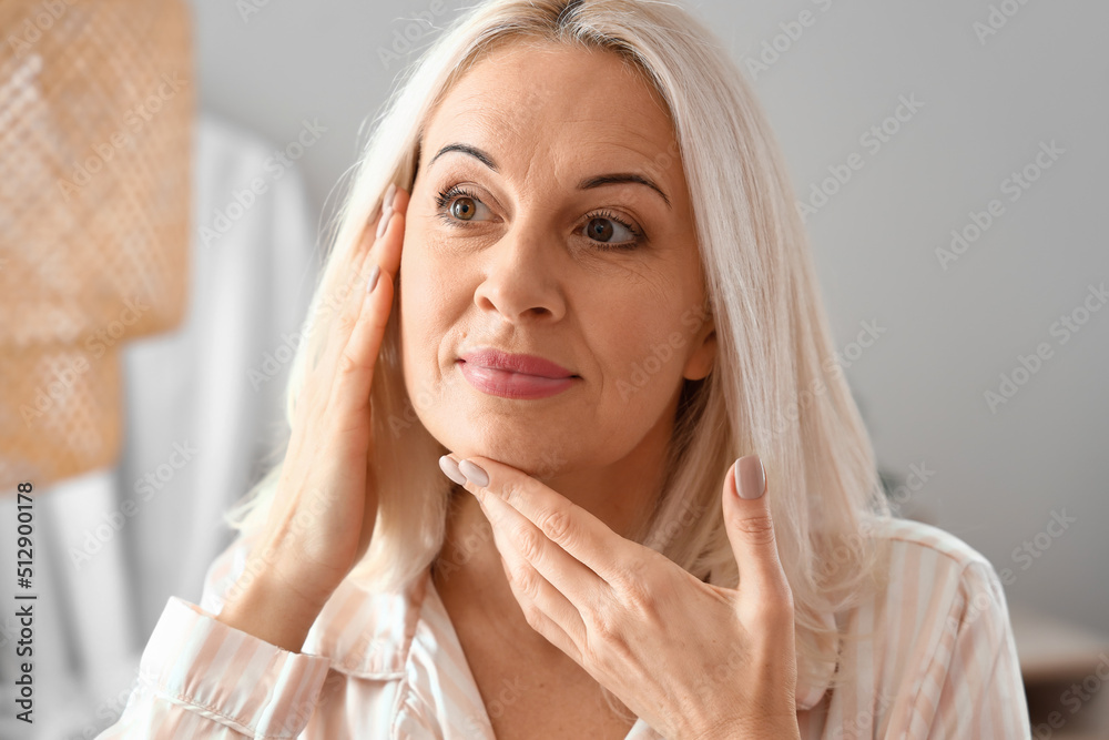 Morning of mature woman giving herself facial massage at home Morning of mature woman giving herself facial massage at home