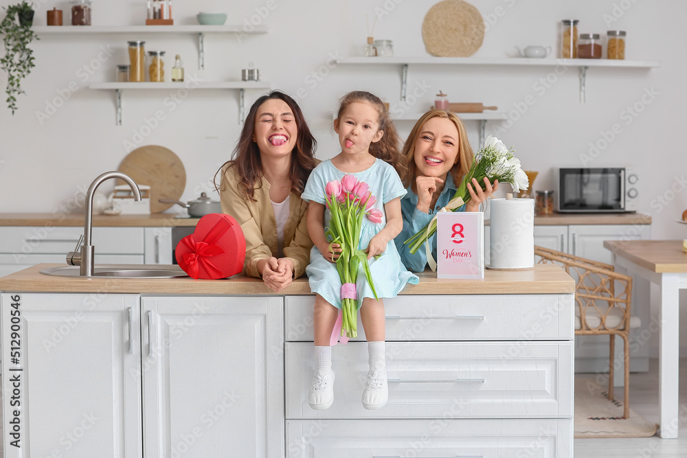Young woman, her little daughter and mother with flowers on International Women's Day at home Young woman, her little daughter and mother with flowers on International Women's Day at home