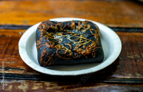 Fényképezés Charcoal Bread on plate on wooden table