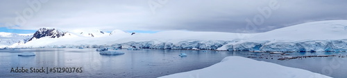 Panorama of icebergs in a bay, surrounded by snow covered mountains, at Portal Point, Antarctica © Angela