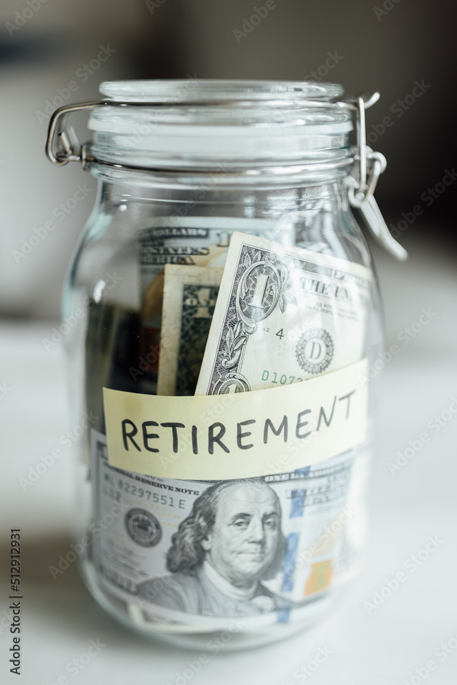 big glass bottle with cash money dollar bill on white marble table at home. Investment business, retirement, finance and saving money for future concept. big glass bottle with cash money dollar bill on white marble table at home. Investment business, retirement, finance and saving money for future concept.
