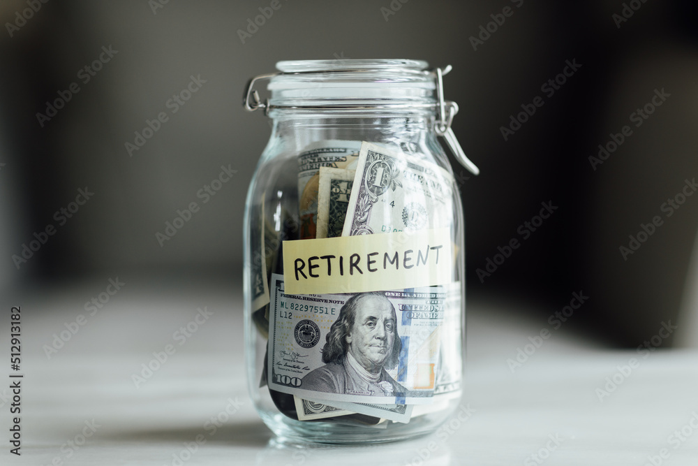 big glass bottle with cash money dollar bill on white marble table at home. Investment business, retirement, finance and saving money for future concept. big glass bottle with cash money dollar bill on white marble table at home. Investment business, retirement, finance and saving money for future concept.