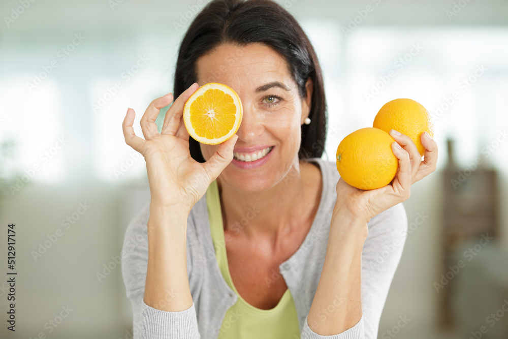 portrait of woman with oranges looking at the camera portrait of woman with oranges looking at the camera