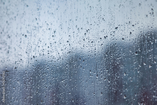 Abstract background with rain drops on window and blurred daylight.