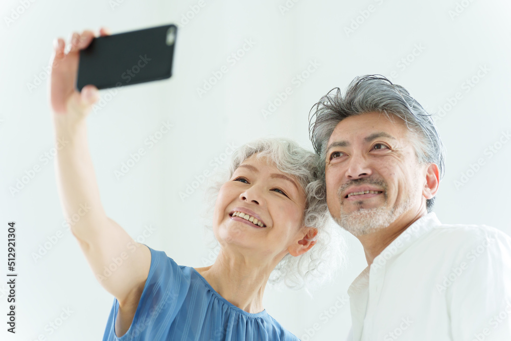 スマートフォンで自撮りをするミドル夫婦 スマートフォンで自撮りをするミドル夫婦