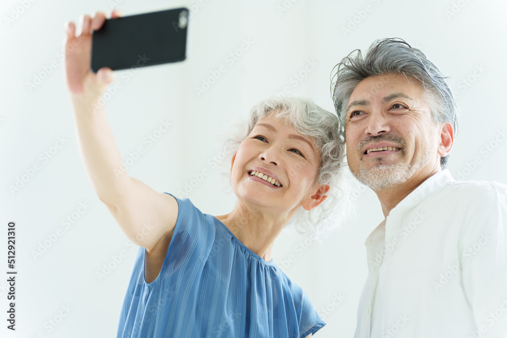スマートフォンで自撮りをするミドル夫婦