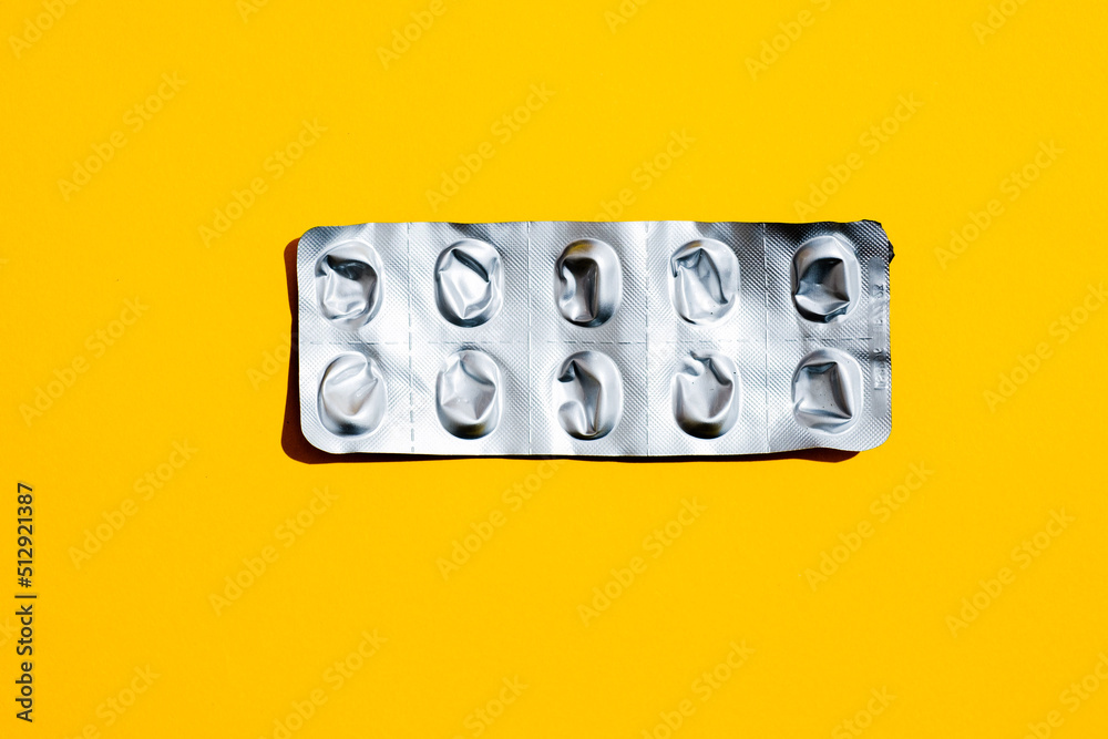 Leere Tabletten Blisterpackung vor gelben Hintergrund, top view