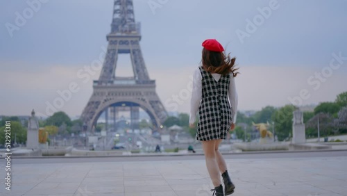 Cinematic footage of a young woman wearing fashionable clothes having fun in Paris at the eiffel tower park and  streets. Concept about european tourism and travels to the capital cities photo