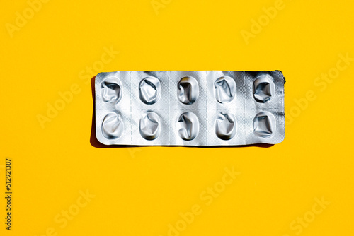 Leere Tabletten Blisterpackung vor gelben Hintergrund, top view photo