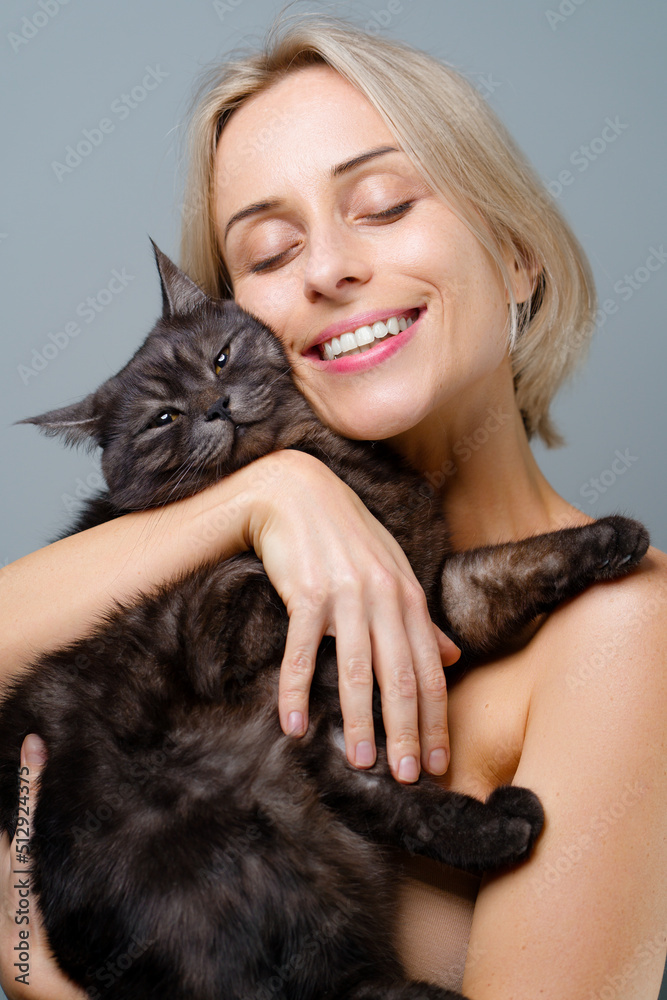 Studio portrait of young blode woman and her adorable black tabby cat. Studio portrait of young blode woman and her adorable black tabby cat.