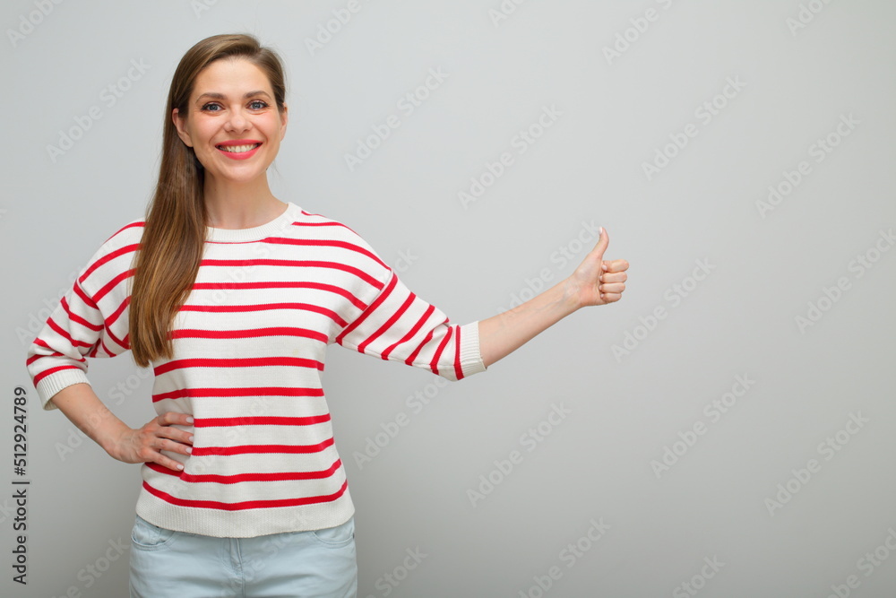Happy smiling woman with long hair standing with thumb up, isolated female portrait, girl in white sweater with red stripes. Happy smiling woman with long hair standing with thumb up, isolated female portrait, girl in white sweater with red stripes.