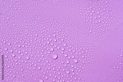 Liquid drops on a lilac background Natural sunshine and shadows. Skincare products. Beauty concept for face and body care in top view.