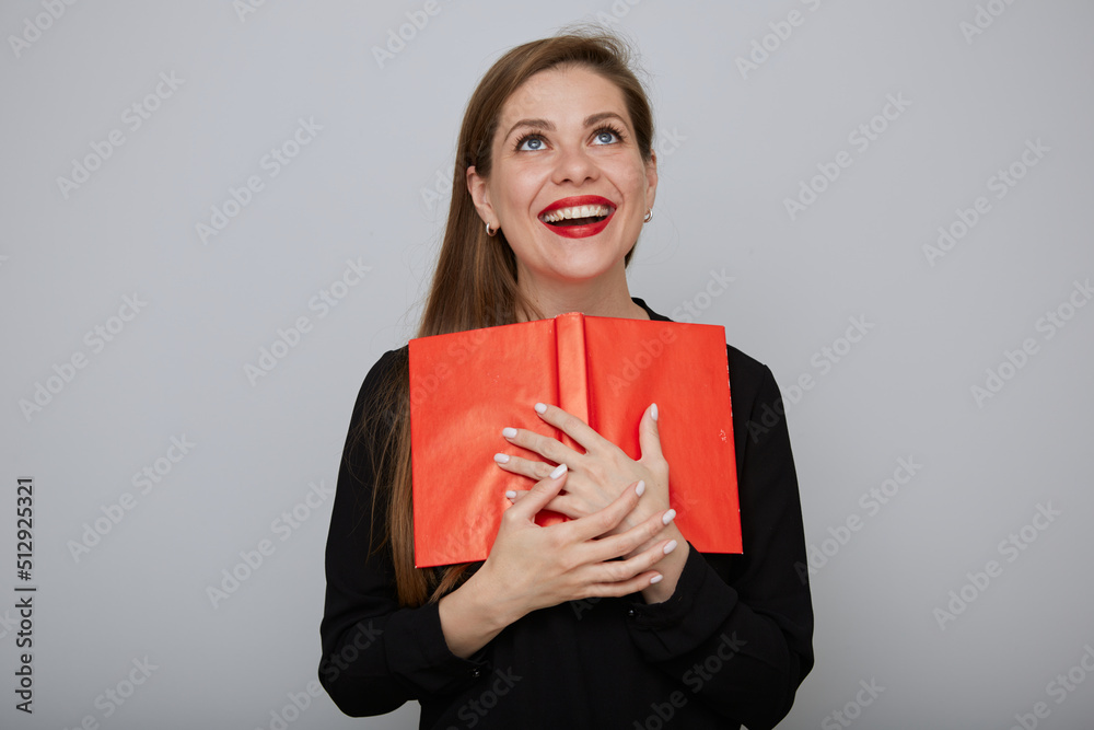 Happy laughing woman student holding red book and looking up. isolated female portrait. Happy laughing woman student holding red book and looking up. isolated female portrait.