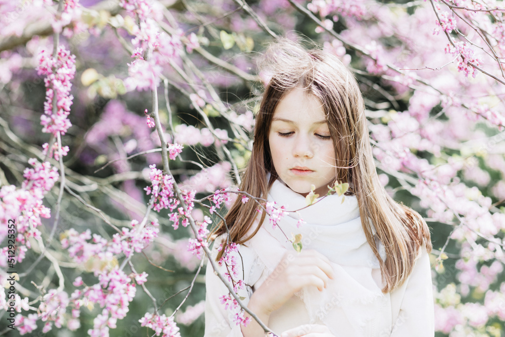 Portrait of a girl on a tree background with pink flowers. Portrait of a girl on a tree background with pink flowers.