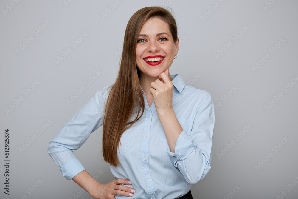Smiling business woman standing with hand on hip and touching her face. Isolated happy female businessman portrait.
