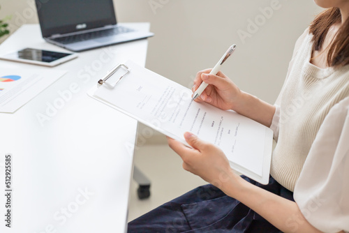 .契約書の内容を審査、サインをする女性 photo