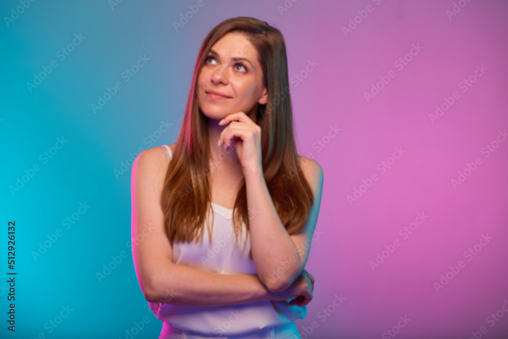 Serious woman looking up, portrait with neon lights colors effect. Female model on neon background Serious woman looking up, portrait with neon lights colors effect. Female model on neon background