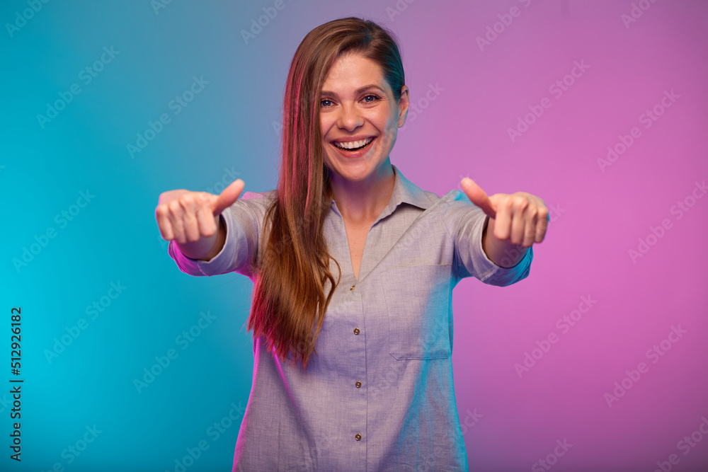 Smiling woman shows thumbs up, portrait with neon lights colors effect. Female model on neon background Smiling woman shows thumbs up, portrait with neon lights colors effect. Female model on neon background