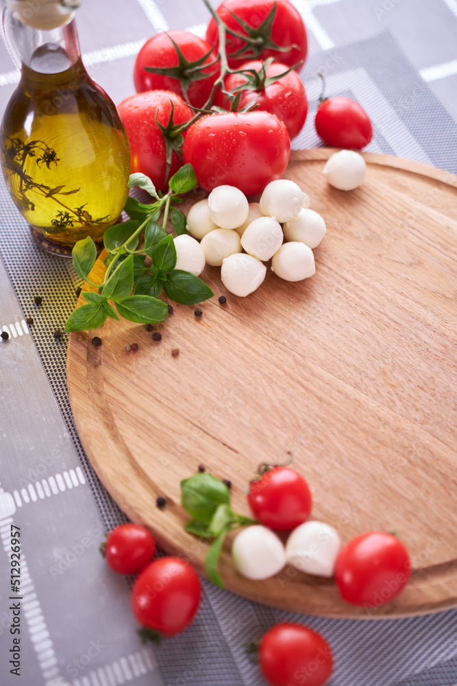 Ingredients for Caprese salad - Mini mozzarella cheese in glass bowl, tomato and basil Ingredients for Caprese salad - Mini mozzarella cheese in glass bowl, tomato and basil