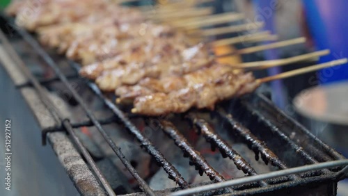 Grilling crocodile meat in street food at Thailand. Meat exotic skewers barbecue in asian street food